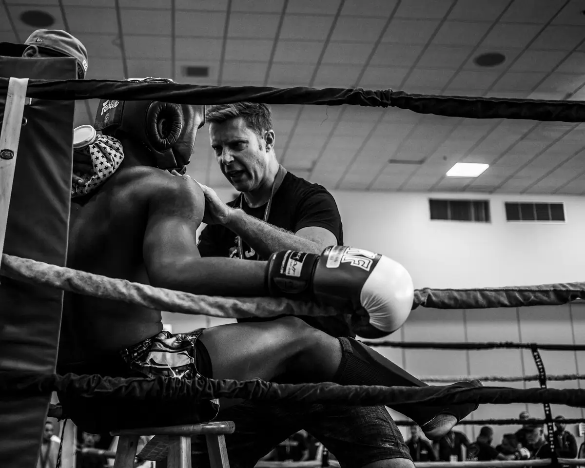 Coach Marco Bell talking to a fighter in the corner